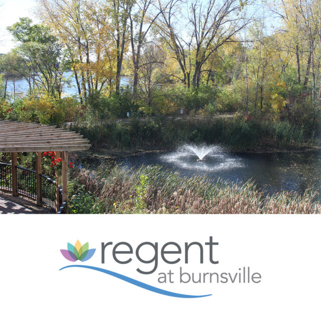 A peaceful view of the fountain near Earley Lake, surrounded by trees and greenery, with the walking trail visible in the background, near Regent at Burnsville.